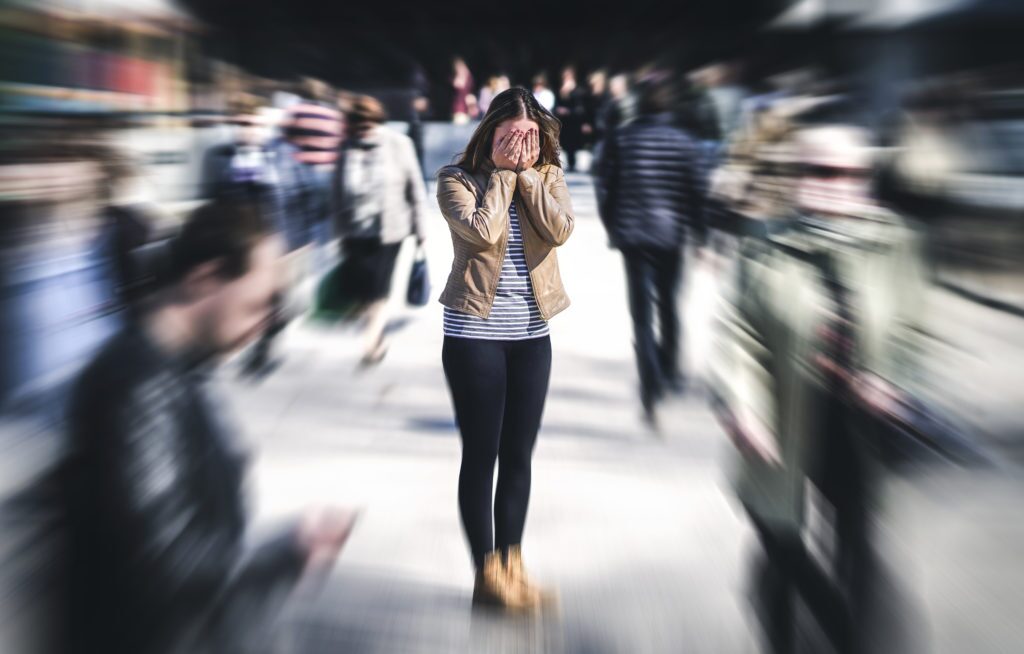 woman hiding her face in public while roaming around.